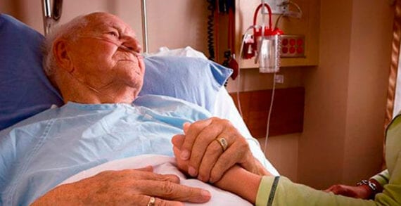 Old man lying in hospital bed holding daugher Half of Canadians don’t even know what palliative care is