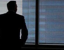 Businessman staring out of window Why many leaders are lonely and what to do about it